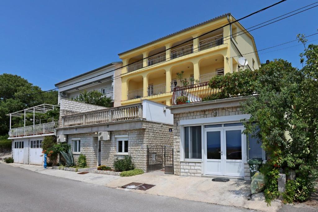 a yellow building with a balcony on a street at Apartments with parking space Dramalj, Crikvenica - 5592 in Dramalj