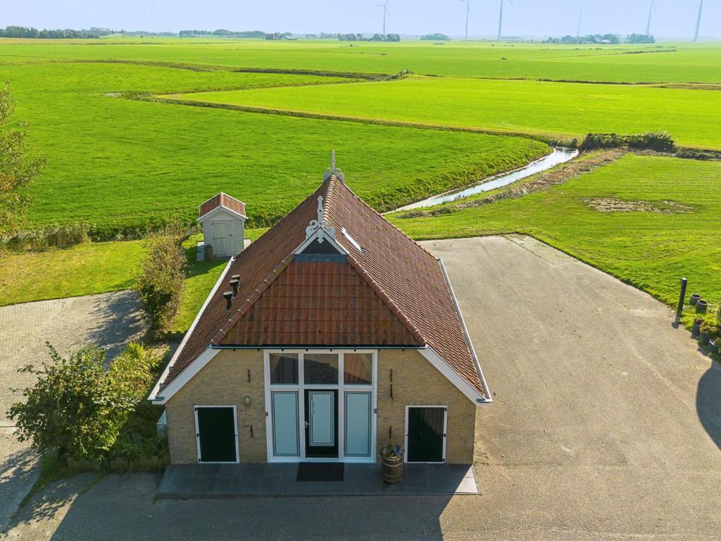 a small house in the middle of a road at Het Koetshuis in Pingjum