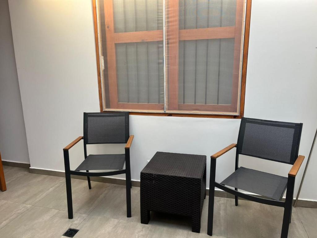 two chairs and a table in front of a window at departamento en ica in Ica