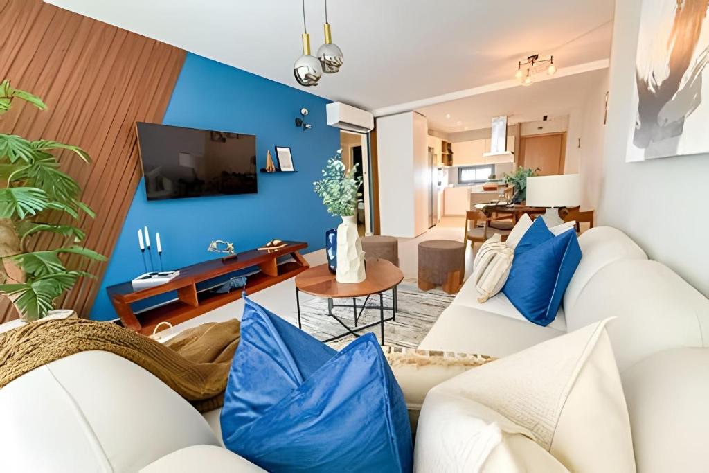 a living room with blue walls and white furniture at Gardenia in Punta Cana