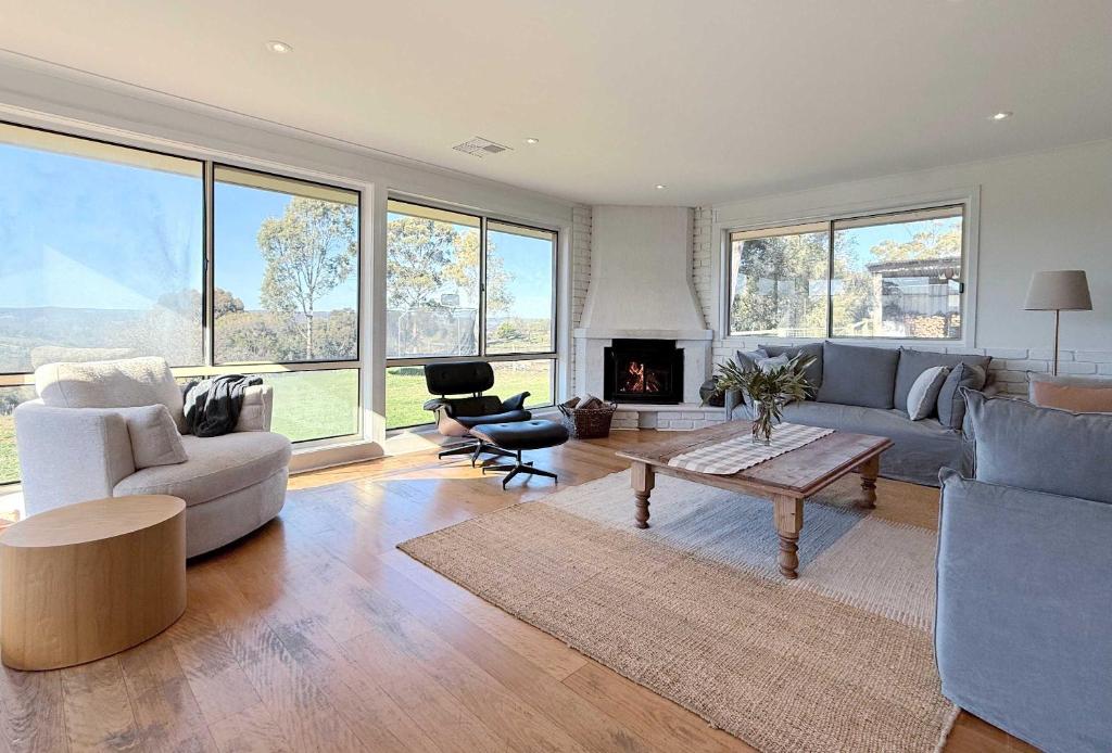 a living room filled with furniture and a fireplace at 4BR Retreat Near McLaren Vale Wineries Adelaide in Clarendon