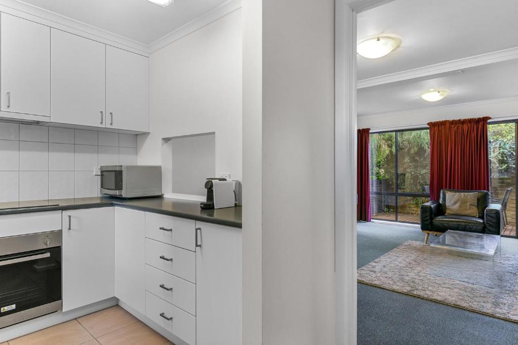 una cucina con mobili bianchi e un soggiorno di 2-Bed Townhouse Retreat in Sandy Bay with Parking a Sandy Bay