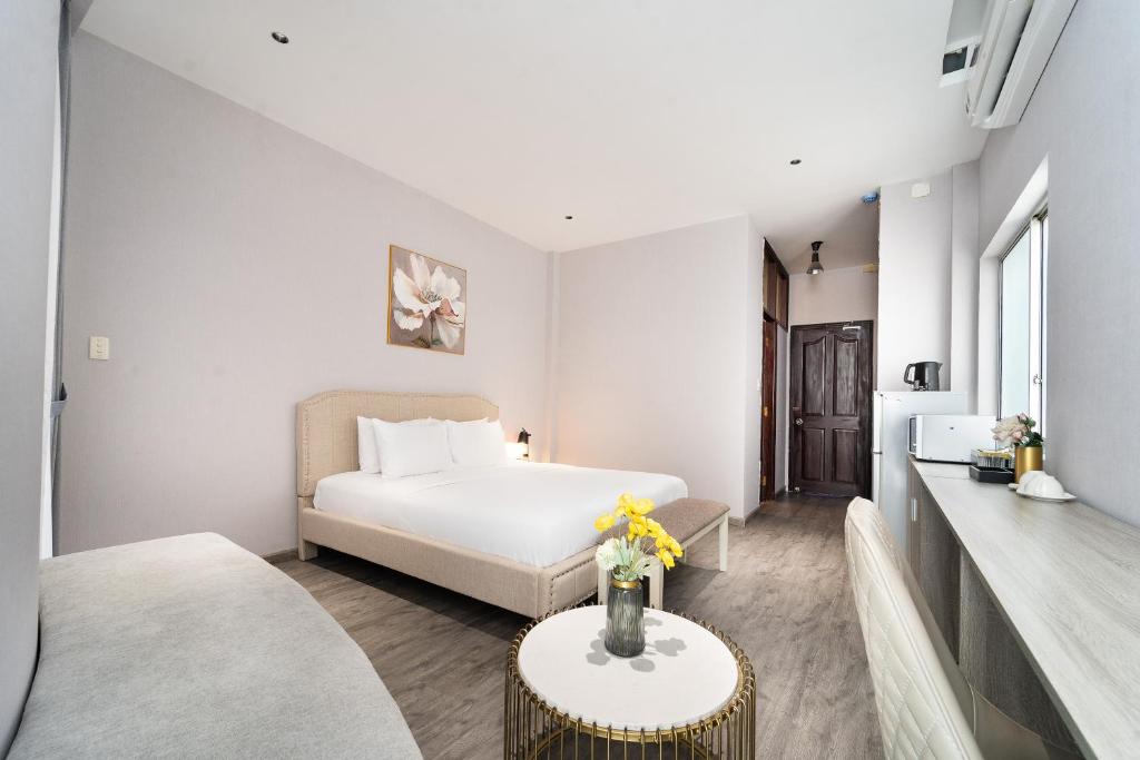 Una habitación de hotel con una cama y una mesa con flores. en Convinia - Free Pick Up, en Ho Chi Minh