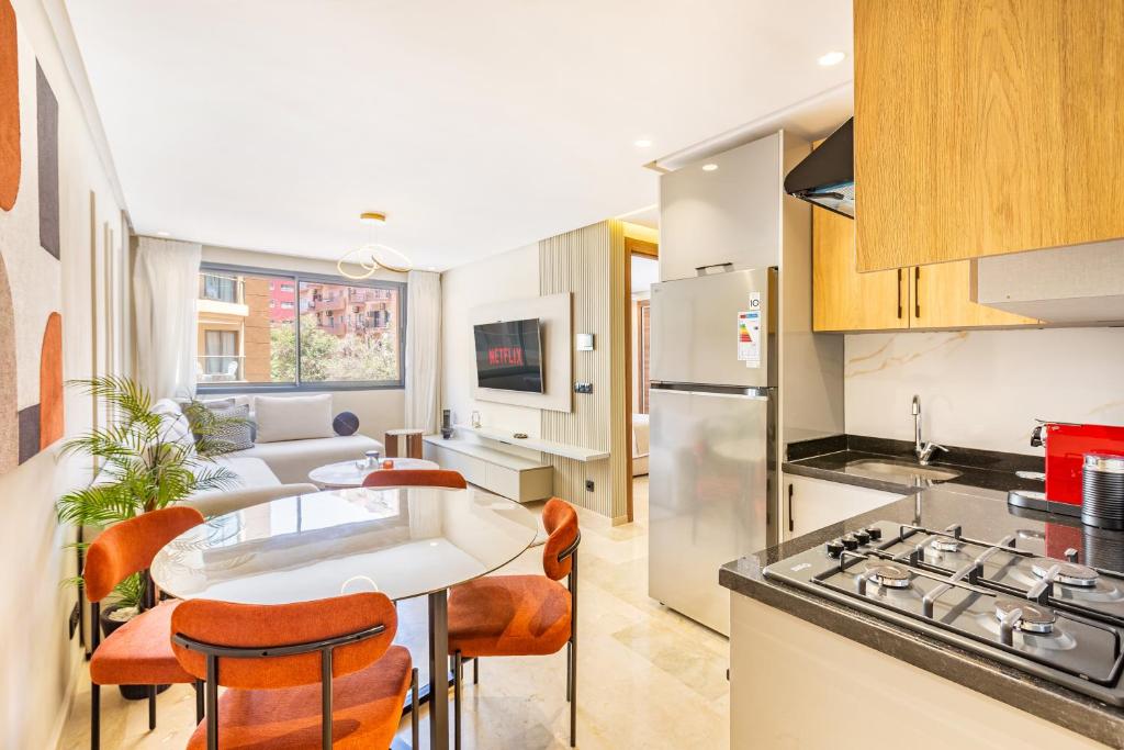 une cuisine et un salon avec une table et des chaises dans l'établissement Prestige Apartment in City Center, à Marrakech