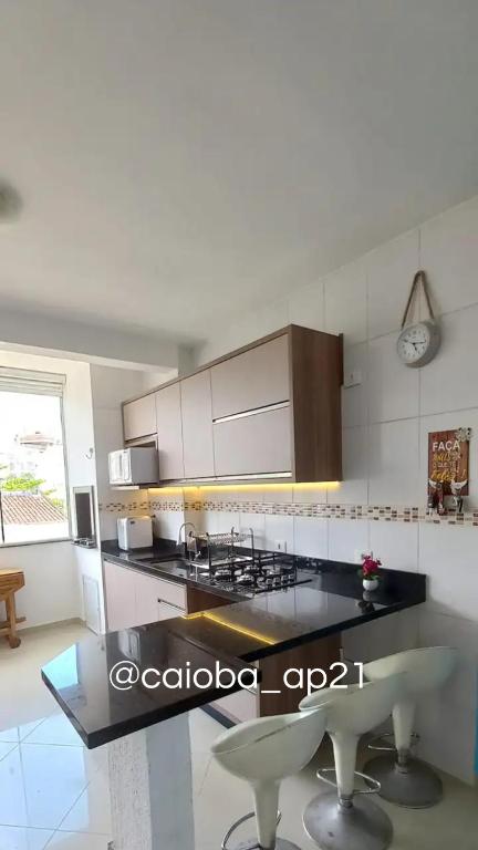 a kitchen with a stove and a counter top at Caioba com excelente localização in Matinhos