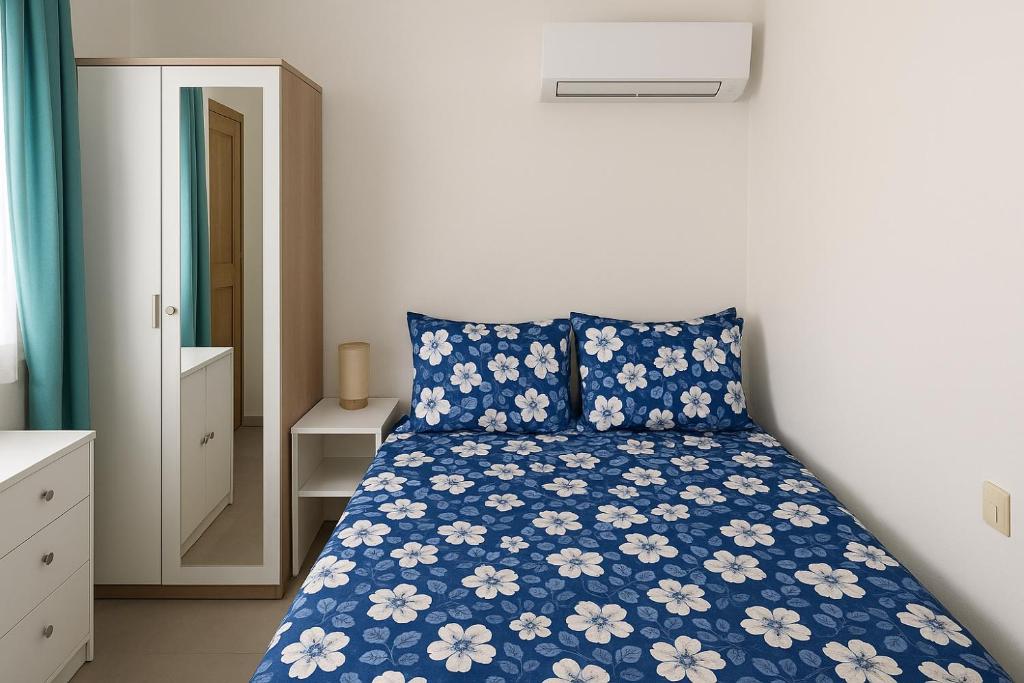 a bedroom with a bed with blue and white sheets at Hong Homestay in Pulau Sarang