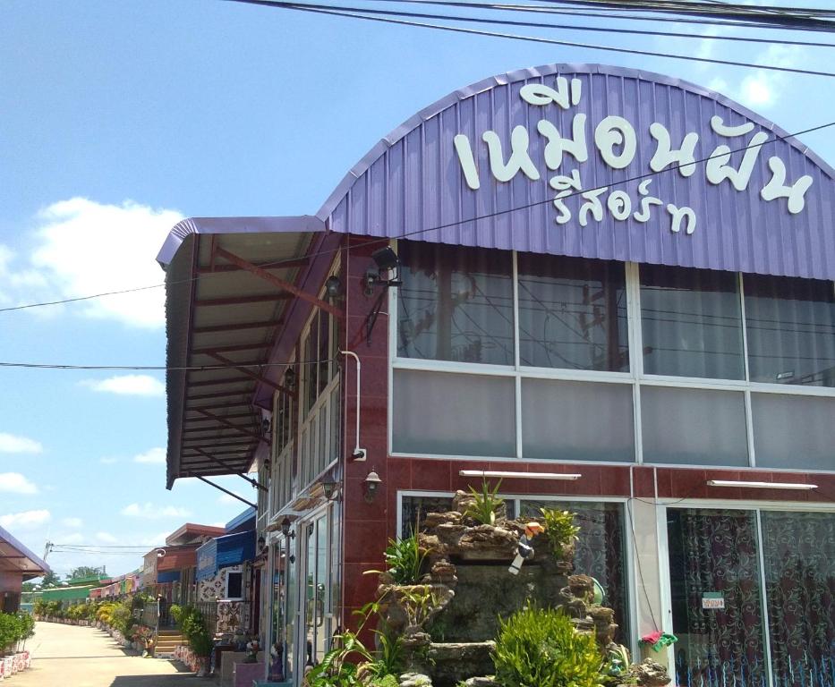 a building with a sign on the side of it at Muean Fhan Resort Aranyaprathet in Aranyaprathet