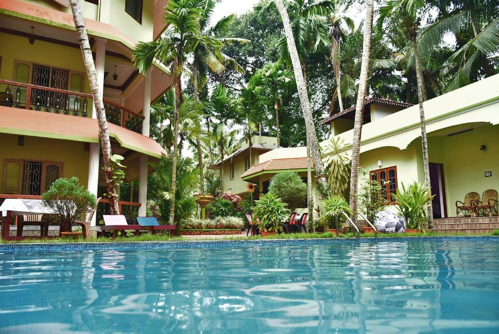 einem Pool vor einem Resort in der Unterkunft Ideal Ayurvedic Resort Kovalam in Kovalam