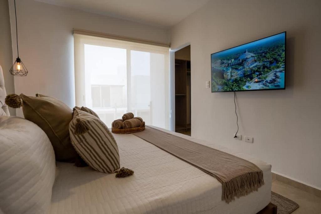 a bedroom with a bed with a television on the wall at 3BR Modern House - Central & Fully Equipped in Cancún
