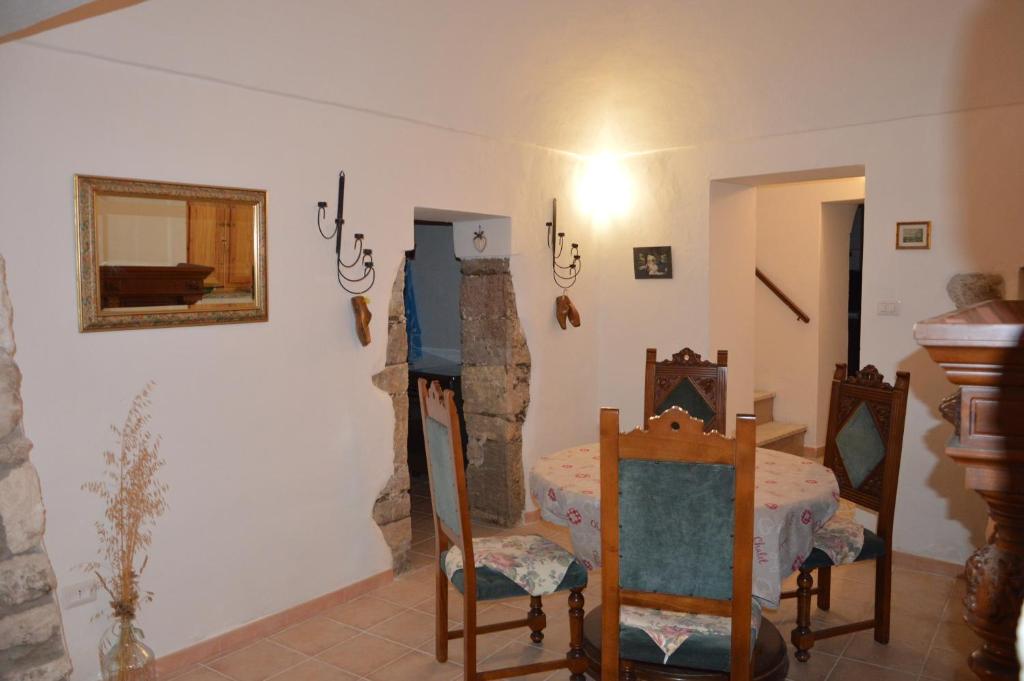 a living room with a table and chairs in a room at P.Tola in Chiaramonti