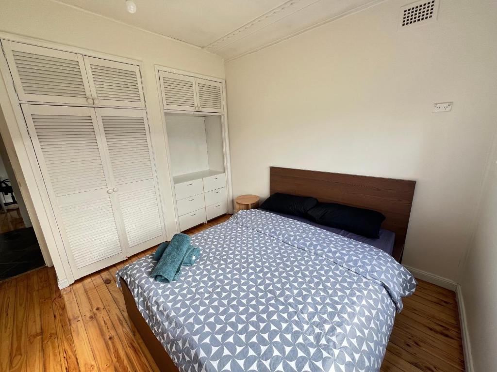 a bedroom with a bed and two white closets at Comfortable Queen Room close to Station and Shops - SH4 in Toongabbie West