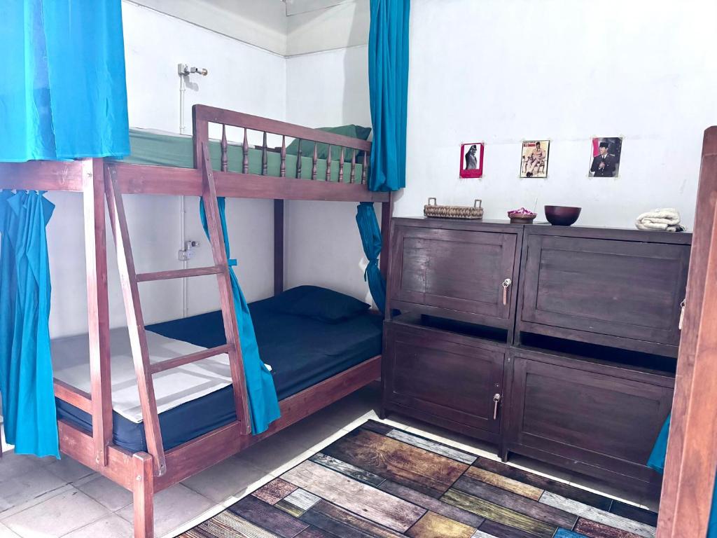 a bunk bed with a ladder and a dresser in a room at Keselatan in Yogyakarta