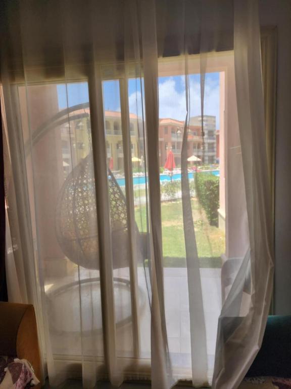 a view of a window with curtains and a chair at بورتو مطروح ألهاني families only in Marsa Matruh