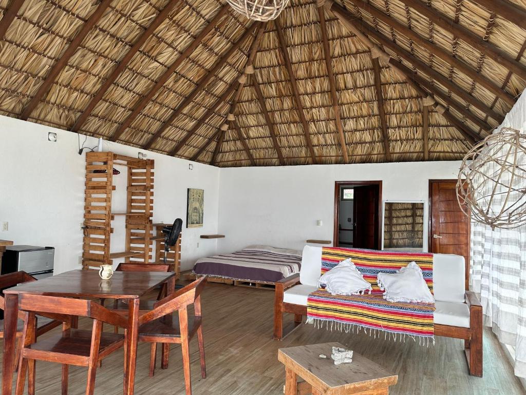 a living room with a bed and a couch and a table at Papapa grecas in Zipolite