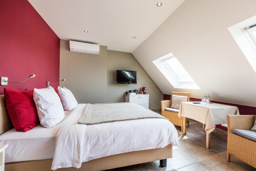 a bedroom with a large bed with red walls at Guesthouse Amfora in Poperinge