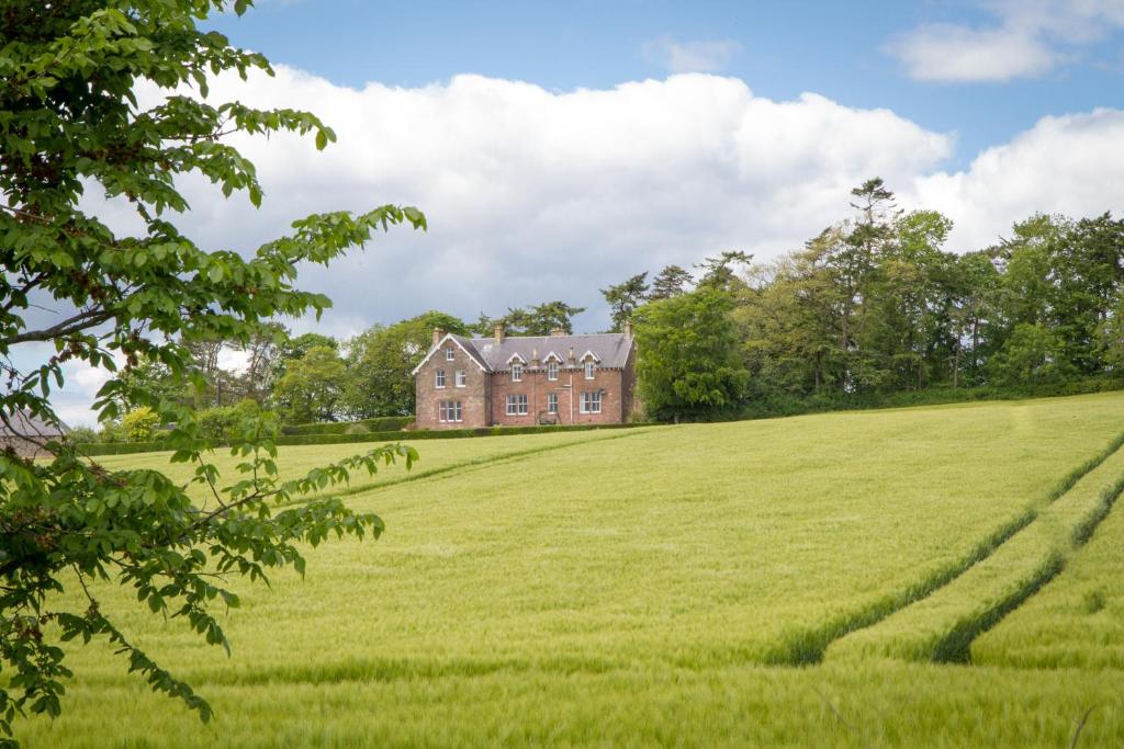 una casa vieja en medio de un campo en Whitehouse Country House en Saint Boswells