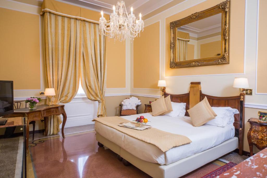 a bedroom with a bed and a mirror at Hotel Bristol Palace in Genova