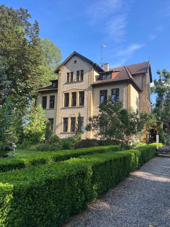 a large house with a hedge in front of it at Pałac Poraj in Wicko