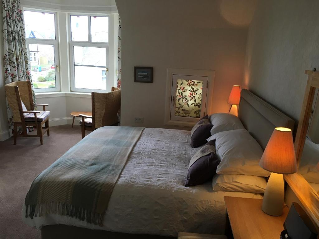 a bedroom with a bed and a lamp at Ronas House in Inverness