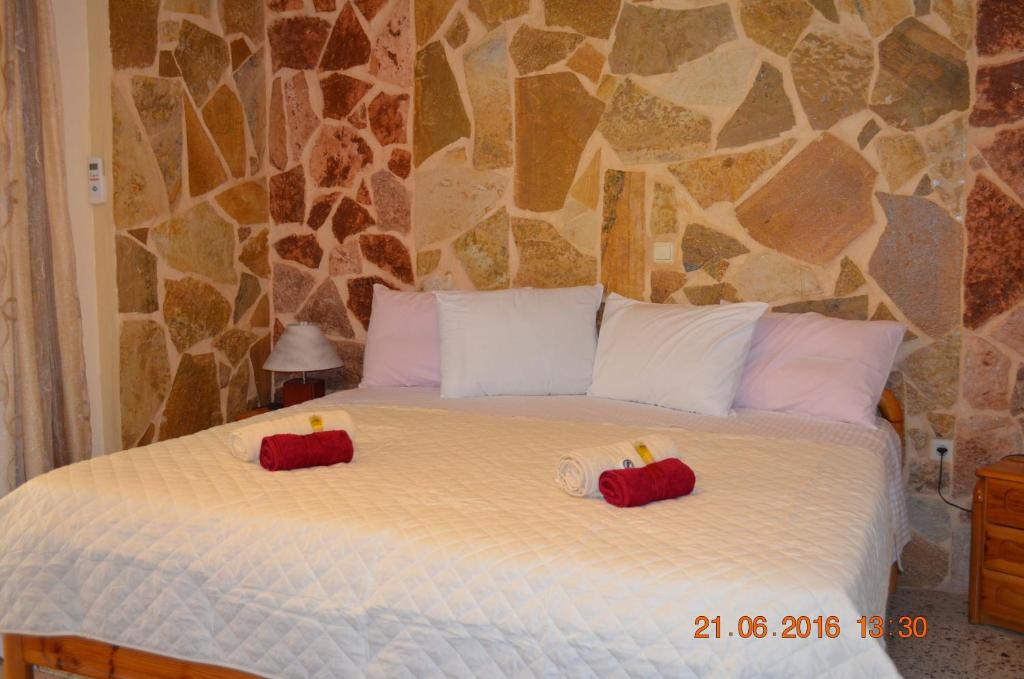 a bedroom with a bed with two candles on it at Apartments Zoumperi in Nea Makri