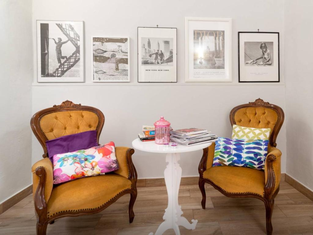 dwa krzesła i stół w pokoju z obrazami na ścianie w obiekcie il Cancelletto CASA VACANZE w mieście Mesagne