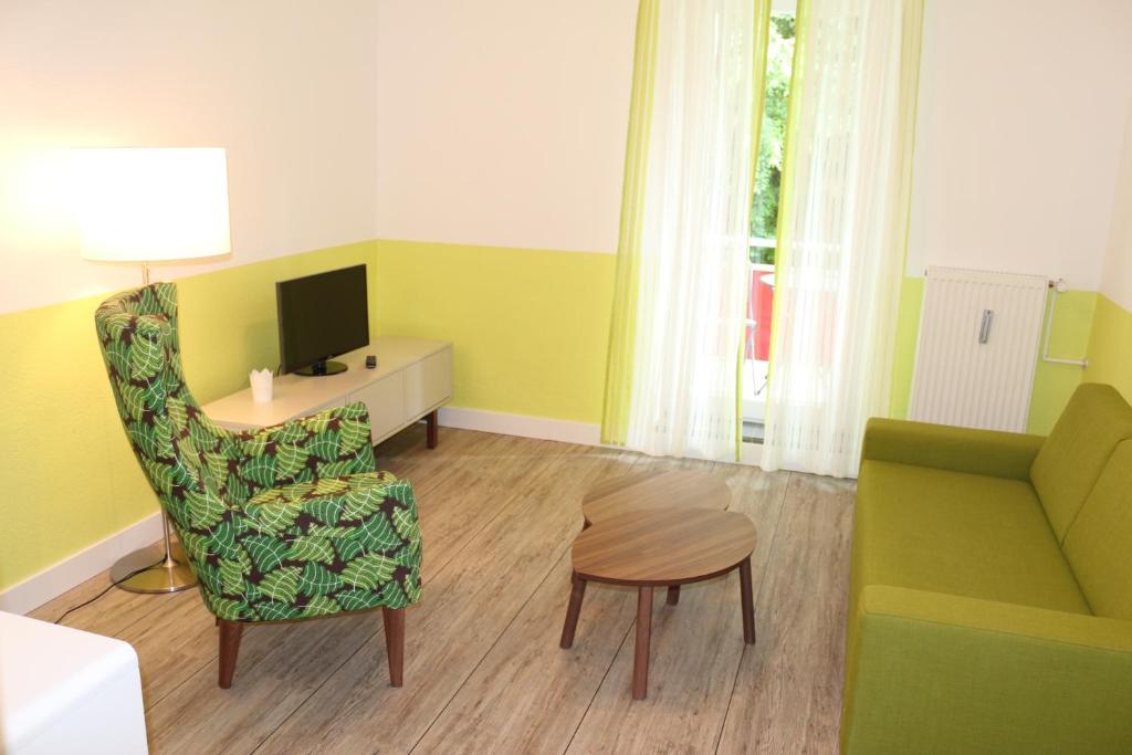 Travel Apartments في مونستر: غرفة معيشة مع أريكة وكرسي وطاولة
