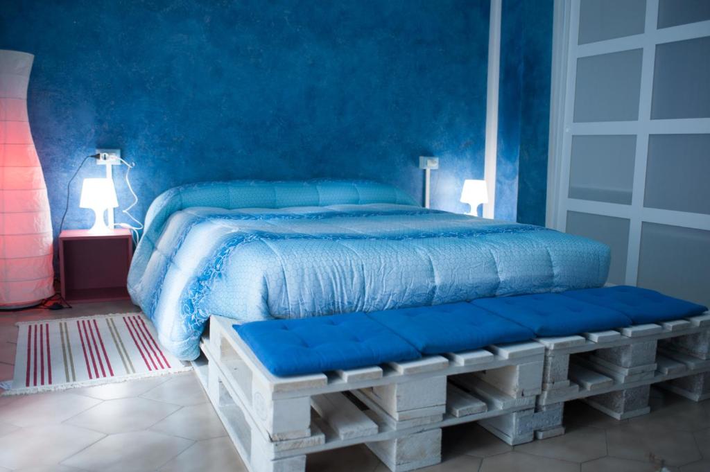 Dormitorio azul con cama y banco en B&B Casa Tua, en Castelfrentano