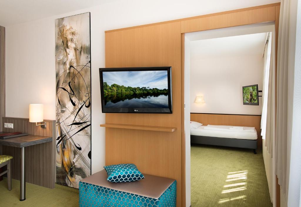 a hotel room with a tv on a wall at Hotel City in Villach