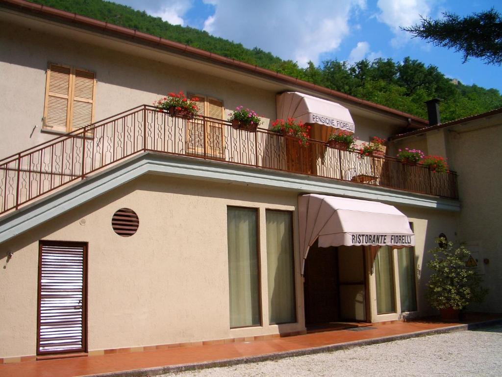 a building with a balcony with flowers on it at Hotel Ristorante Fiorelli in Preci