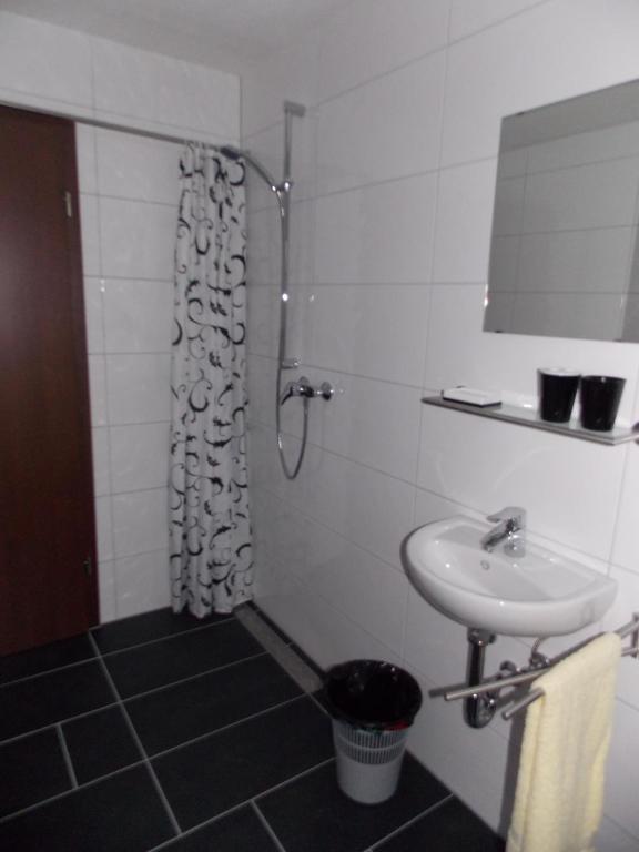 a white bathroom with a sink and a shower at Ferienhaus Hofmann Strüth 3 in Röttingen