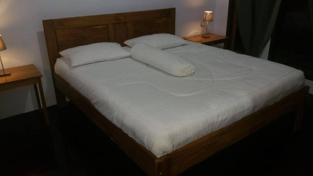 a bed with white sheets and pillows on it at Vakantie Vila Wab in Watnil