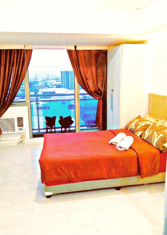 a bedroom with a bed and a large window at Azure Staycationcation by Nairah in Manila