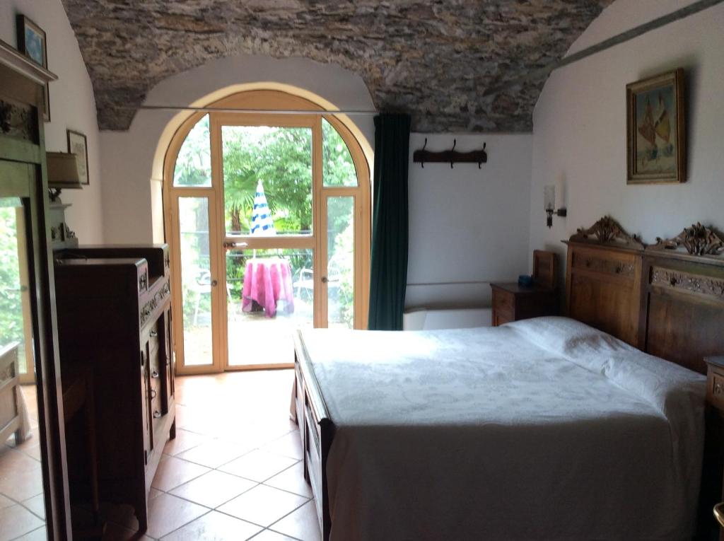 a bedroom with a bed and an open door at Hotel Villa della Quercia in Verbania