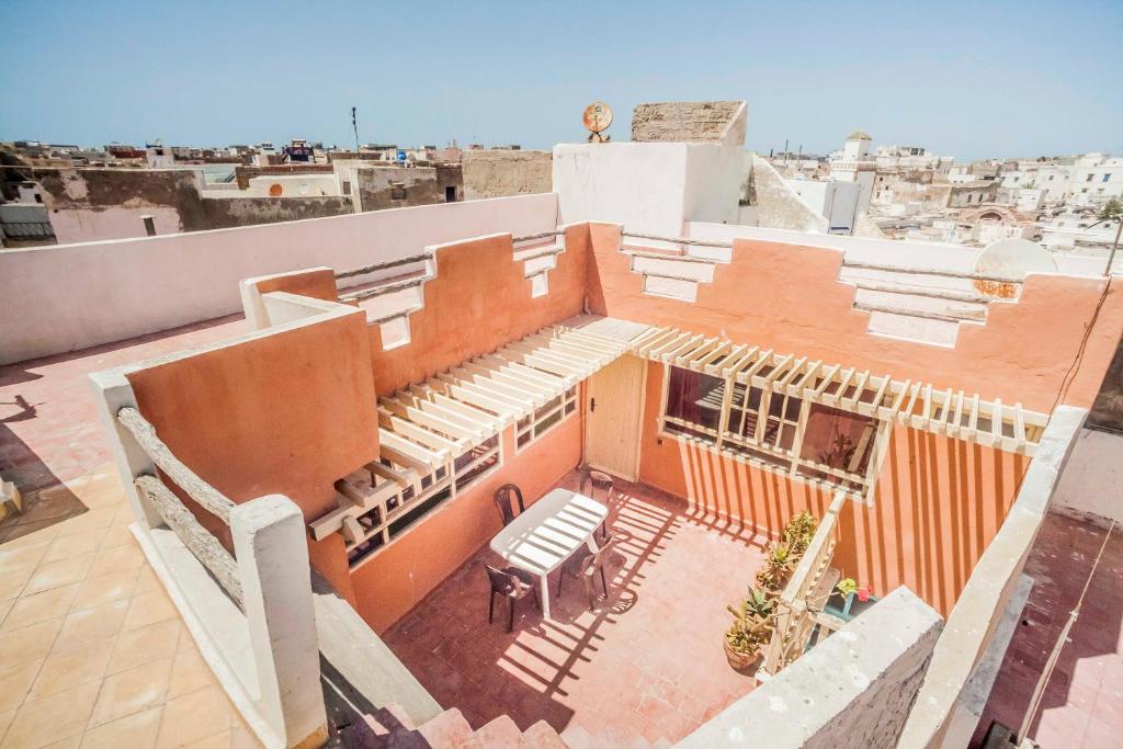 une vue aérienne sur un bâtiment avec une table sur le toit dans l'établissement Dar karam, à Essaouira