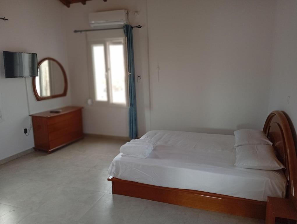 a bedroom with a bed and a dresser and a mirror at Tourni Cozy Chios in Chios