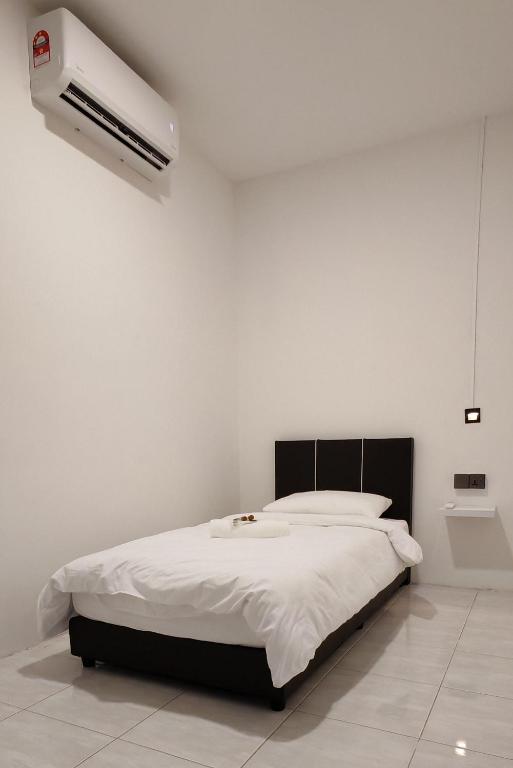 a white bedroom with a bed and a air conditioner at 23 Inn Singlebed Share Bathroom No Window in Bukit Mertajam