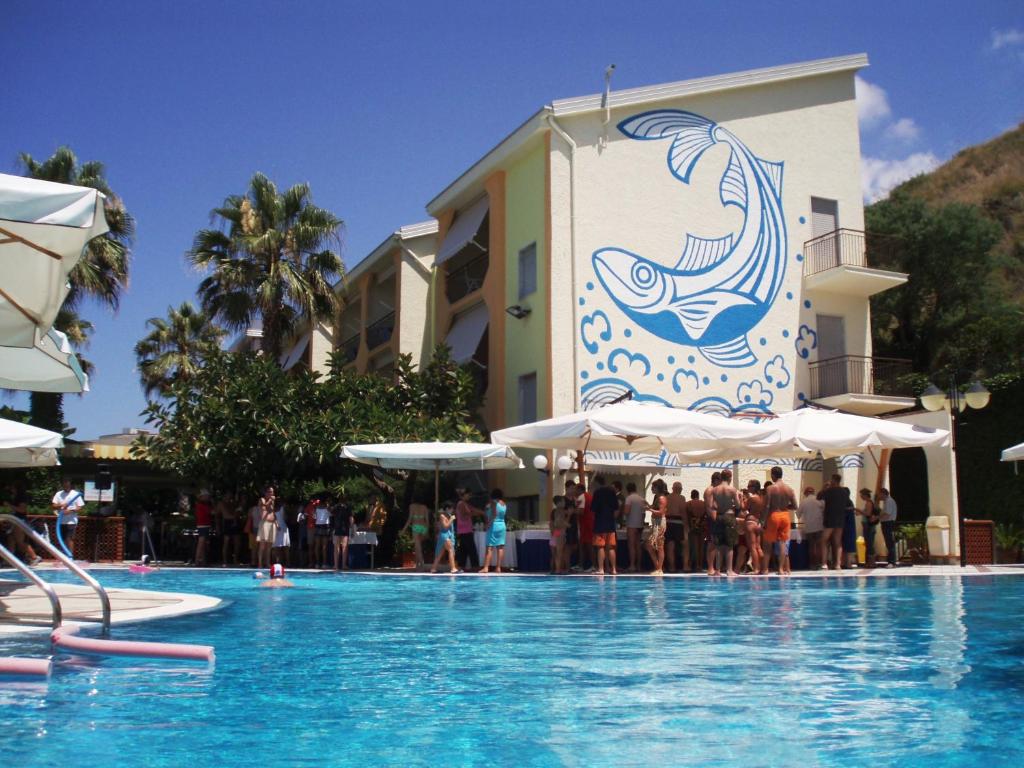 un grupo de personas de pie frente a una piscina en Hotel La Tonnara, en Amantea