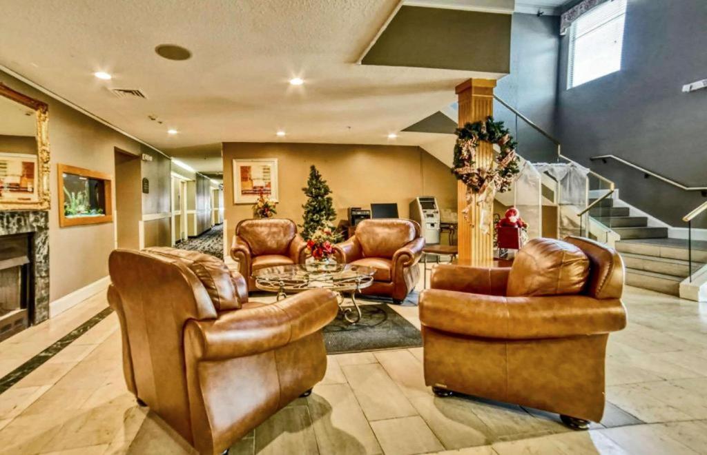 a living room with leather furniture and a fireplace at Econo Lodge Raleigh near Walnut Creek Amphitheatre in Wilders Grove