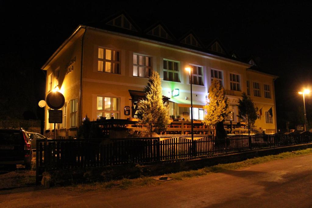 a building with a fence in front of it at night at Hotel Obecná Škola in Svatý Jan pod Skalou
