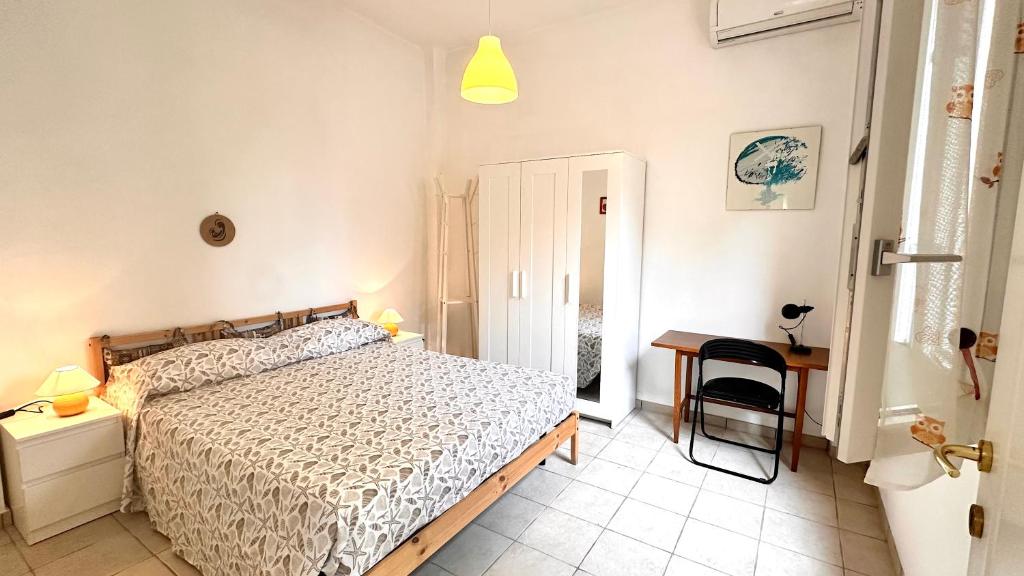 a bedroom with a bed and a table and a chair at la casetta di Ponente in San Bartolomeo al Mare