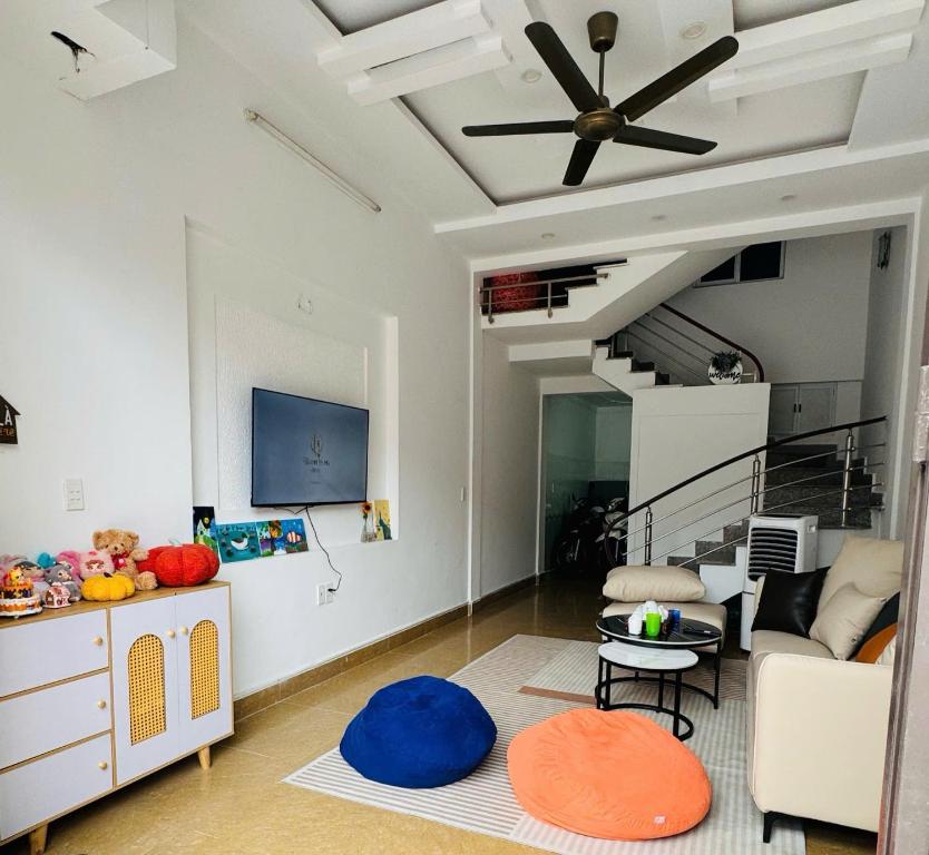 a living room with a couch and a ceiling fan at An Homestay in Dong Ra