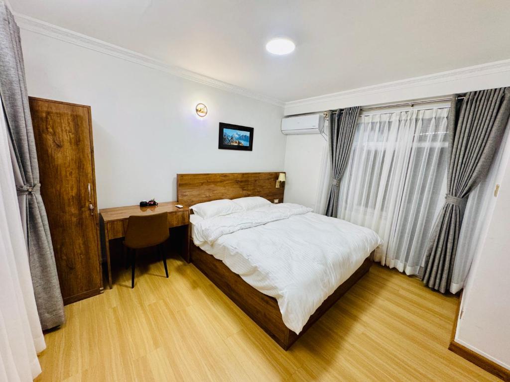 una camera da letto con un letto e una scrivania di Ivanna stay kuleshwor K4 a Kathmandu
