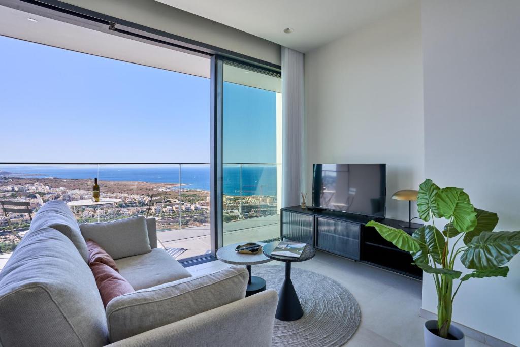 a living room with a couch and a large window at Luxurious Level 26 Getaway in St. Julianʼs