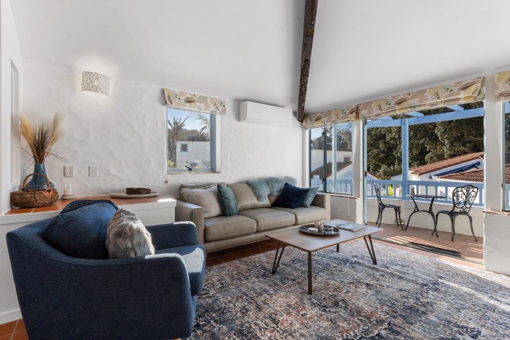 a living room with a couch and a table at Sea Breeze - Orewa Oceanside Apartments in Orewa