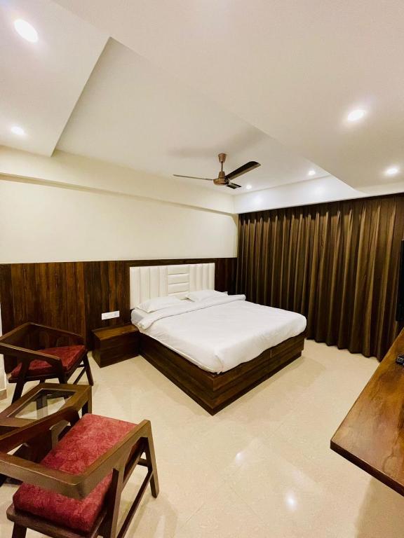 a bedroom with a bed and a table and a chair at Casa Kasauli in Kasauli