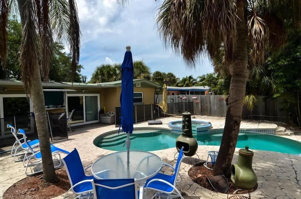 a glass table and chairs next to a swimming pool at 349 Avenida Madera in Siesta Key