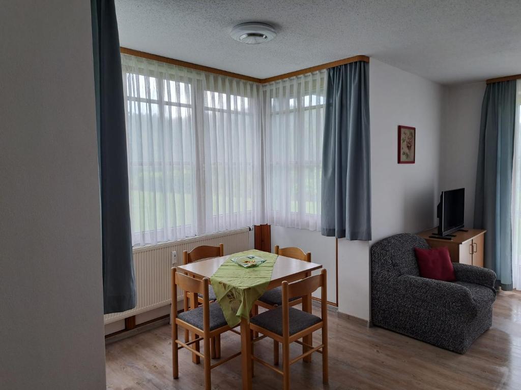 ein Wohnzimmer mit einem Tisch und einem Stuhl in der Unterkunft Ferienland Sonnenwald Ferienwohnung im Sonnenwald Apartment 5 in Langfurth 