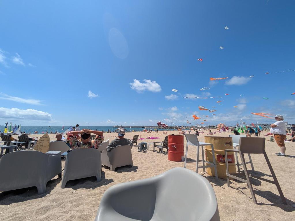 eine Gruppe von Menschen, die am Strand auf Stühlen sitzen in der Unterkunft Maison de vacances 400 m de la plage et du port de la Turballe in La Turballe