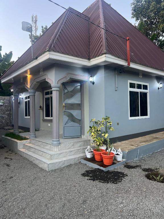 a small white house with plants inront of it at Upendo Moja House in Nkoanrua
