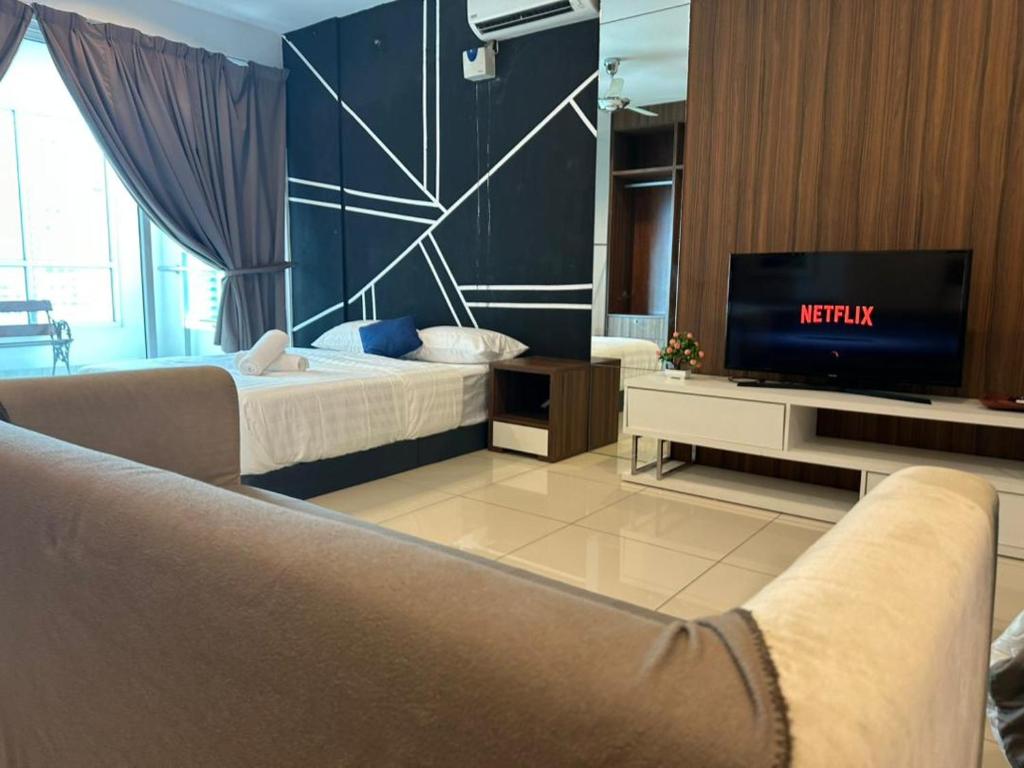 a living room with a couch and a television at Mansion One Seaview Studio 4 pax Gurney in George Town